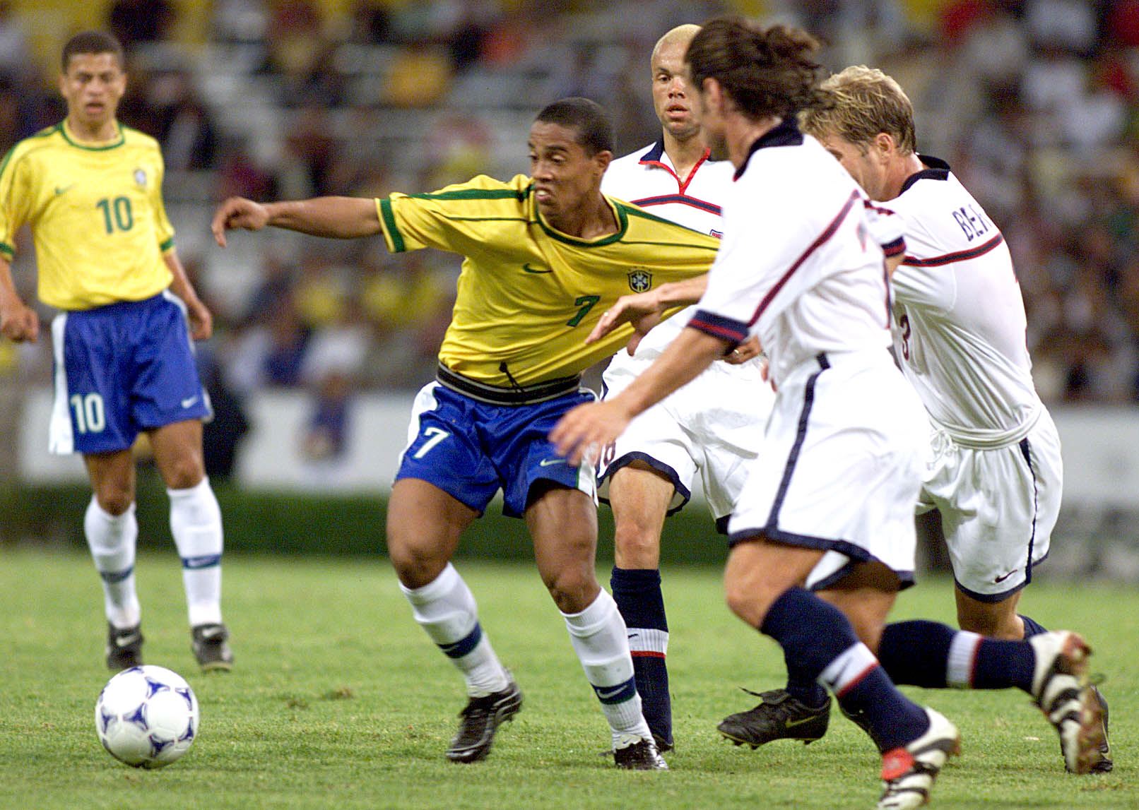 Ronaldinho (C) of Brazil is held by US players dur